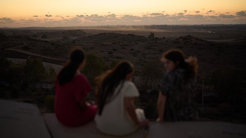People observe buildings that were destroyed during the Israeli ground and air operations in the northern of Gaza Strip as they visit a sightseeing area in Sderot, southern Israel, Tuesday, Oct. 14, 2025.